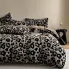 Conjunto de quatro peças de pelo de coelho Classe A em preto, capa de edredom de veludo de leite com estampa de leopardo elegante, lençol de baixo de flanela quente e lençol de cima para outono e inverno
