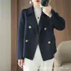 Abrigo corto de lana pura, simple y elegante, con solapa estilo traje y botones de doble botonadura, diseñado para disimular y estilizar la figura, un abrigo de lana indispensable para el lugar de trabajo.
