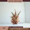 Escena de decoración de escaparate de tienda de ropa con flores de otoño, juncos, hierba y flores secas para una transmisión en vivo con temática femenina