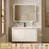 Tocador de baño engrosado y ahorrador de espacio con diseño en color crema, que cuenta con un lavabo redondeado, lavabo cerámico integrado y un lavabo de una sola pieza.