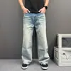 Jeans de mezclilla para hombre en tono azul claro degradado con dobladillo curvo, lavados y desgastados, pantalones de pierna ancha ligeramente acampanados, corte relajado, pantalones casuales versátiles