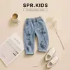 Conjunto de otoño estilo coreano para niños, chaqueta de béisbol con bloques de color, camiseta con dibujos animados, jeans con graffiti, elegante conjunto casual de tres piezas