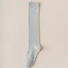 Venta al por mayor de fábrica calcetines de becerro largos de color liso JK japoneses para otoño e invierno, calcetines altos de moda de color liso para mujer, calcetines JK para mujer