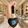 Llavero de corazón con ojo maligno estilo europeo y americano, con incrustaciones de diamantes en toda la superficie, colgante de bolso en forma de corazón con incrustaciones de diamantes de lujo ligero, llavero para coche
