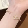 Popular en Xiaohongshu: Pulsera de camelia con circonita de diamante completo ultra brillante para mujer, de alta gama, elegante, versátil, anillo ajustable