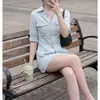 Uma camisa polo azul chique e sofisticada combinada com uma minissaia ajustada - um conjunto de duas peças perfeito para passeios de verão e encontros, apresentando uma cor sólida que ilumina o tom da pele.