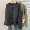 Foto real de un cárdigan suéter suave y atmosférico para mujer, perfecto para otoño e invierno, una prenda exterior de punto roja retro para el Año Nuevo