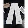 Calça jeans de luxo estilo americano com bordado cruzado e efeito desgastado, com patches de couro, calça longa versátil casual slim-fit para o dia a dia
