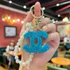 Estilo Popular Europeo y Americano Llavero con Logo de Letra Hueca Incrustado con Arcilla y Pedrería Doble C con Sensación de Alta Gama, Colgante para Bolso de Cadena de Perlas y Pedrería