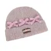 Gorro de punto de estilo coreano inspirado en la dopamina con un lazo, diseñado para mujeres, que proporciona calor y protección para los oídos en otoño e invierno, y favorece el rostro; un sombrero pequeño y elegante para estudiantes