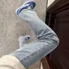 Jeans azul claro, ligeramente acampanados para hombre, perfectos para atuendos de otoño, creando un efecto de piernas largas, corte limpio, pantalones de corte recto con pierna curva