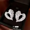 Aretes de botón con forma de corazón hueco de circón con pasador de plata, lujo ligero y alta gama, elegancia francesa, aretes de mujer elegantes y versátiles