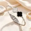 Pulsera clásica europea y americana de trébol blanco y negro de acero de titanio para mujer, joyería simple de acero inoxidable moderna y versátil, venta al por mayor desde el fabricante