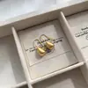 Pendientes sencillos de metal con forma de frijol para mujer, combinables con todo, estilo frío, temperamento de alta gama, pequeños pendientes de libro rojo para mujer.