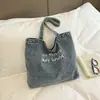 Bolsa de lona de mezclilla lavada con textura en tono azul vintage para estudiantes universitarias, casual y versátil para viajes y compras, bolso de hombro