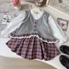 Conjunto de Tres Piezas para Niña Primavera y Otoño 2026, Nueva Camisa de Manga Larga Estilo Coreano, Chaleco de Punto con Encaje y Falda para Venta Transfronteriza