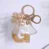 Fornecedor da Fábrica Chaveiros de Metal Dourado com Pedras e Tassel de Borboleta, Pingentes de Chave e Charms para Bolsas Femininas