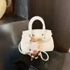 Bolsa de Mão de Couro Litchi de Alta Qualidade para Mulheres Nova Chegada Primavera 2026 Pingente de Boneca Bolsa de Ombro Único Bolsa Transversal Elegante para o Dia a Dia