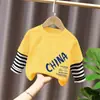 Camiseta de manga larga de algodón puro para niño 2026 primavera y otoño nueva elegante de dibujos animados estilo dos piezas falsas camiseta base de primavera para niño