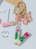 Suministros del Fabricante Llaveros con Flores Secas Prensadas 26 Letras del Alfabeto Inglés Llaveros con Borla de Mariposa Charms para Bolsos de Mujer