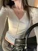 Camiseta de mujer con cuello en V, costura central, manga larga, tela suave y elástica, corte corto, ajuste ceñido, diseño simple, estilo coreano y un look elegante y atmosférico.