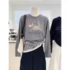 Camiseta de manga larga moderna y versátil para mujer con diseño de hombro recto, hecha de algodón puro, en un elegante color gris con un diseño sofisticado y textura acanalada, perfecta para el otoño.