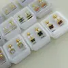 Aretes Mini Gota de Aceite Dorados de Acero de Titanio en Caja Aretes Sencillos de Tornillo Cuatro Hojas Pendientes de Marca Grande