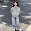 Nueva colección de primavera y otoño para niños de tamaño mediano y grande: un elegante conjunto de dos piezas que presenta un top a rayas con cuello y detalles de patchwork, y pantalones vaqueros con estampado de estrellas