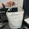 Bolso tipo cubo grande informal para mujer, nuevo modelo otoño 2026, alto valor estético, color liso, diseño de remaches, bolso de hombro simple para el día a día