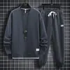 Traje de punto gofre para hombre, nuevo conjunto de dos piezas casual deportivo de manga larga y pantalón largo para primavera y otoño, atuendo moderno y elegante