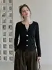 Camiseta negra de manga larga con cuello en V y decoración de botones para mujer, nuevo estilo otoño 2026, abertura irregular, top entallador