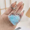 Colgante acrílico relleno de aceite, llavero luminoso con forma de taza de iceberg, colgante para coche, botella con forma de arena movediza, accesorio para mochila escolar.