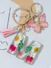 Suministros del Fabricante Llaveros con Flores Secas Prensadas 26 Letras del Alfabeto Inglés Llaveros con Borla de Mariposa Charms para Bolsos de Mujer