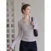 Foto real de moda estilo coreano: Top de punto de manga larga con cuello polo para mujer, colección otoño 2026, corte ajustado y elegante, capa interior