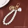 Nuevo Pulsera Creativa de Perlas, Llavero Colgante Lindo de Corazón de Melocotón de Aleación, Accesorio Metálico de Cabeza de Belleza, Bolso Decorativo para Mujer