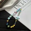Diseño nuevo y único con cuentas florales tachonadas de diamantes, una correa para teléfono linda y versátil, y un dije de cámara CCD.