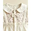 Novo macacão para bebê menina com estampa floral, gola boneca e detalhe de laço, perfeito para passeios