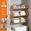 Baño de estilo abierto con un inodoro, un soporte para pañuelos de papel y toallitas húmedas encima del inodoro, y un estante de pared para toallas perfumadas