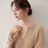 Elegante y versátil, este suéter de cachemira estilo Henley, semiabierto y con cuello en V, presenta botones de concha y mangas largas, lo que lo hace perfecto para la oficina