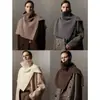 Um item essencial para criar looks estilosos: um xale de gola alta em lã merino super fina com uma fenda, oferecendo várias maneiras de usá-lo
