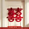 Nueva decoración de habitación de bodas estilo chino, con caracteres auspiciosos, decoraciones festivas para puertas, borlas y arreglos florales, creando un telón de fondo pintoresco para las fotos de boda.