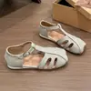 Nuevas sandalias romanas planas retro 2026 para primavera y verano, con tira en T y diseño de punta semi-cerrada calada, ligeras y en un nuevo estilo chino para mujer