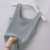 Camisola branca usada sobre um blazer de alças largas, combinada com uma regata curta de seda gelada, regata estilo BM justa ao corpo