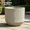 Projetados modularmente, vasos de cimento segmentados podem ser combinados para criar floreiras grandes para a área modelo do escritório de vendas.