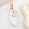 Corrente de Celular Elegante com Flor e Pérolas, Pulseira de Pérolas de Luxo para Mulheres, Acessório de Pulso da Moda Estilo Chanel, Mais Vendido Internacionalmente