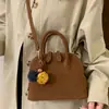 Bolsa de concha de nicho de alta gama para mujer 2025 Nuevo estilo coreano retro de un solo hombro bandolera pequeña bolsa de mensajero bolsa de boliche