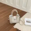 2026 Nuevo Bolso Cubo de Nicho Estilo Coreano para Mujer con Lindo Colgante de Caballo, Bolso Versátil de Hombro y Cruzado con un Toque de Moda de Alta Gama