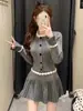 Look Outono/Inverno: Um conjunto de top de tricô feito à mão na cor Fitz Rainy Night Gray e saia plissada com contas de tricô
