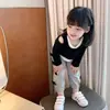 Roupa Feminina Infantil para Primavera e Outono Camiseta de Manga Longa Estilo Ocidental para Bebê Personalidade Infantil Marca Tendência Estilo Coreana Moda Top com Ombro à Mostra Falso Duas Peças