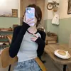 Nova base layer outono e inverno 2026 para mulheres, apresentando uma gola sofisticada média-alta, mangas compridas e uma bainha franzida, oferecendo um visual de alta qualidade